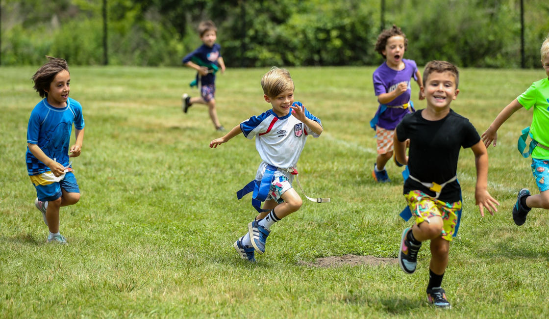 Campers running across the field during a game