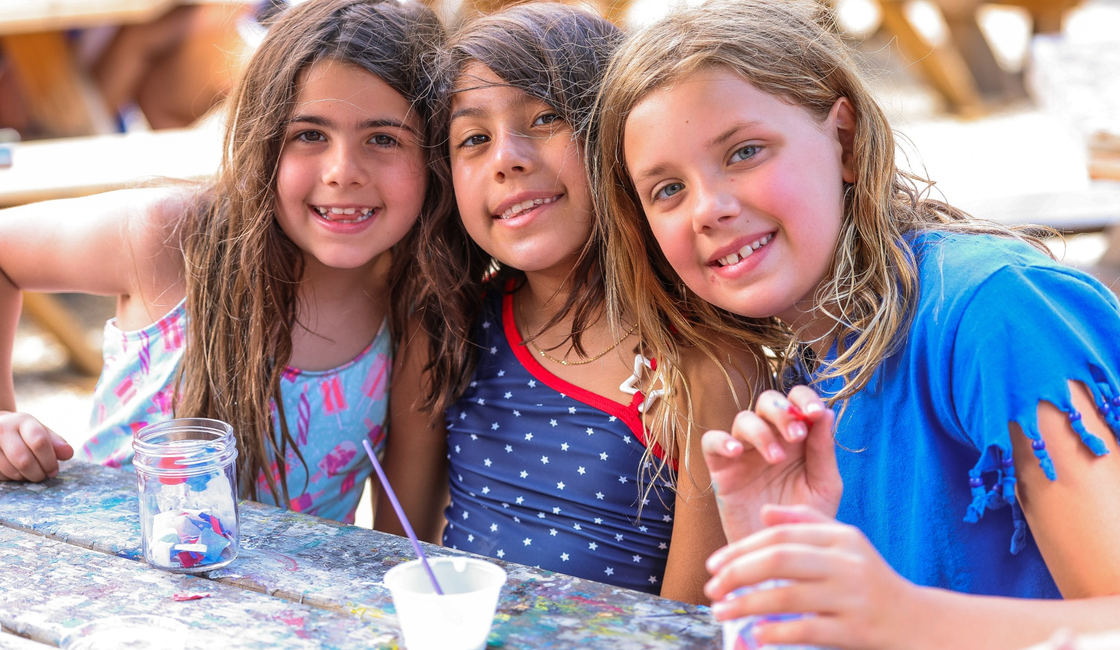 Three campers spending time together at an outdoor table